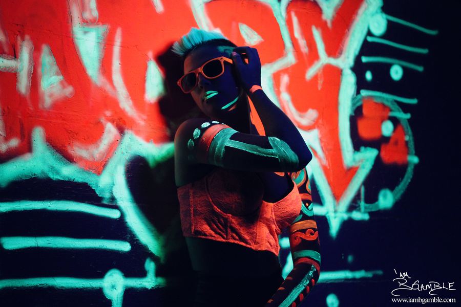 Portrait under blacklight, graffiti backdrop